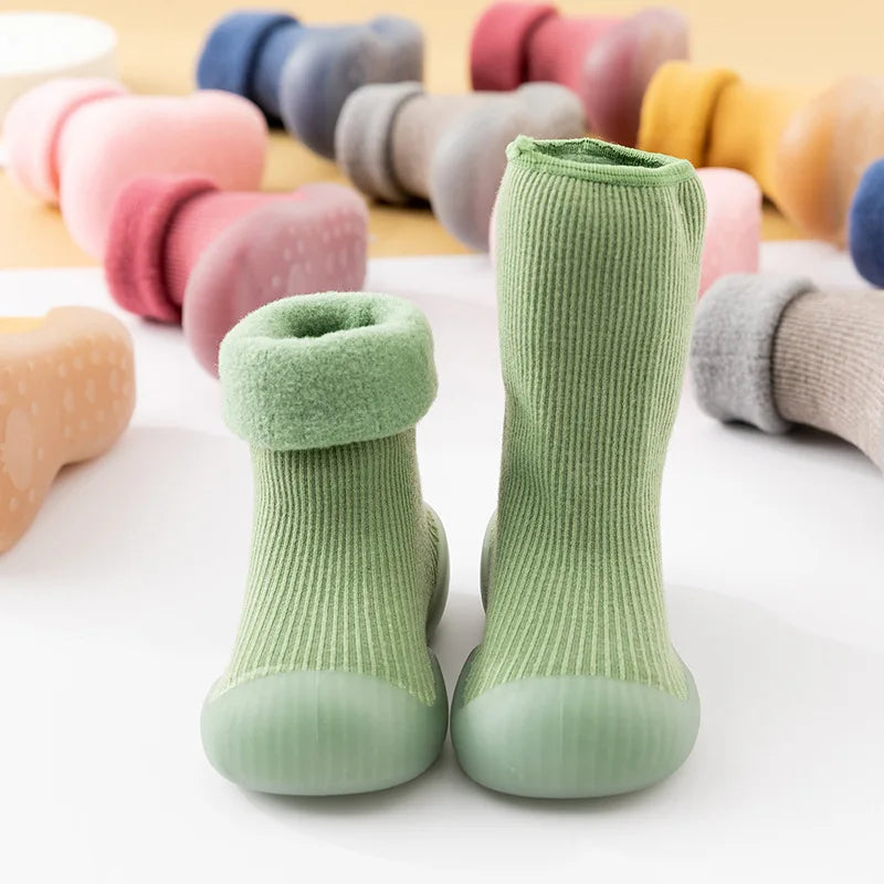 Een groen paar StapSokjes, met de andere kleuren vervaagd op de achtergrond