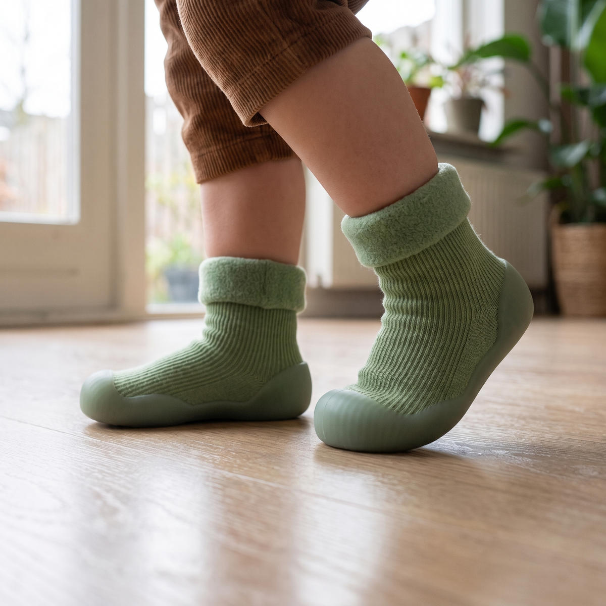 De rubberen zool van de StapSokjes op een houten vloer, van dichtbij